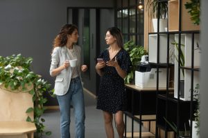 Two,Multicultural,Female,Colleagues,Enjoying,Coffee,Break,Time,,Discussing,Working